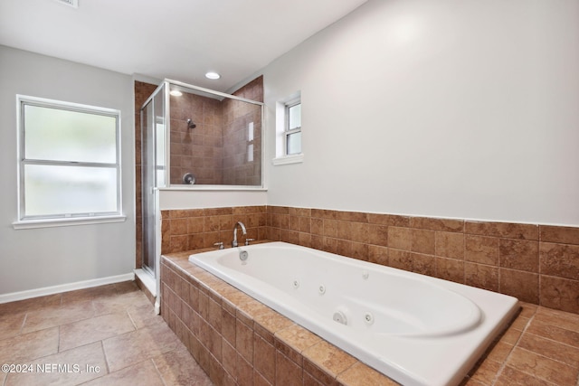 bathroom featuring separate shower and tub and a healthy amount of sunlight