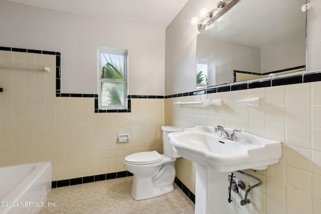 bathroom with tile patterned flooring and tile walls