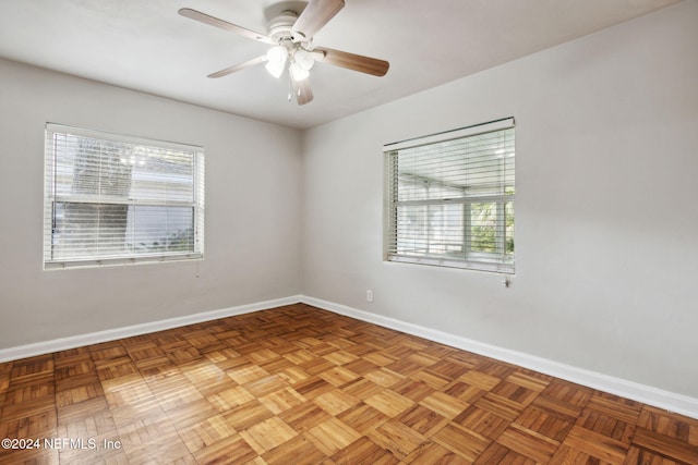 unfurnished room featuring ceiling fan, a healthy amount of sunlight, and light parquet floors