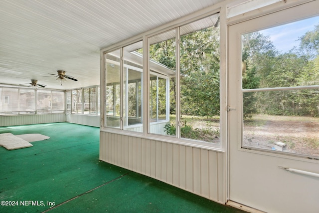 unfurnished sunroom featuring ceiling fan and a healthy amount of sunlight