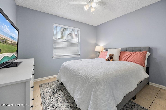 tiled bedroom with a textured ceiling and ceiling fan