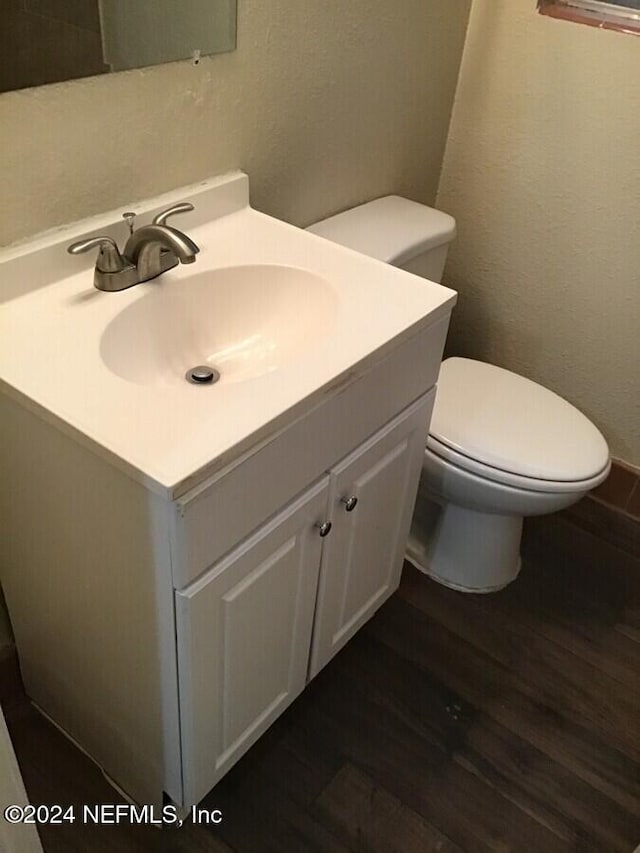 bathroom with vanity, toilet, and wood-type flooring