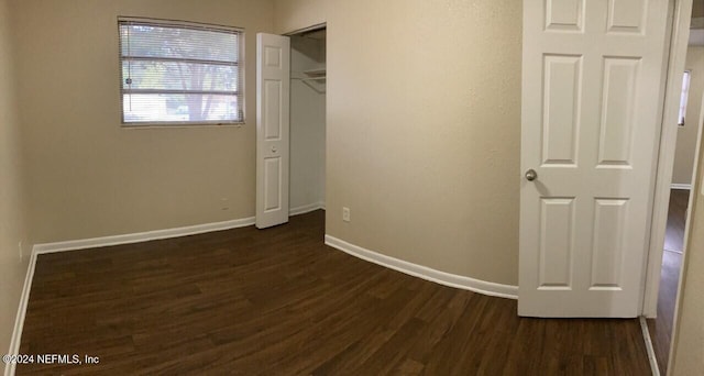 unfurnished bedroom featuring dark hardwood / wood-style floors and a closet