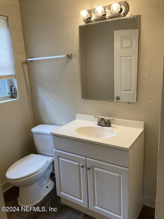 bathroom with hardwood / wood-style floors, vanity, and toilet