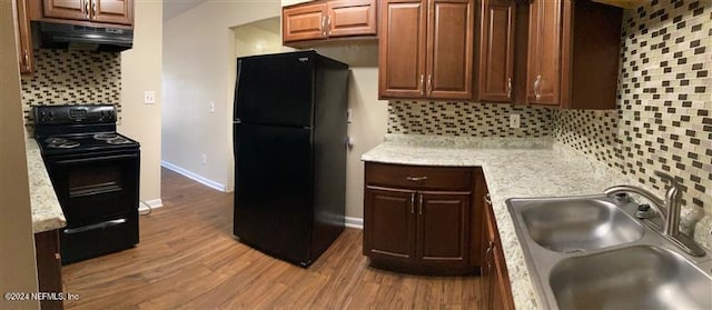 kitchen featuring decorative backsplash, sink, hardwood / wood-style flooring, and black appliances