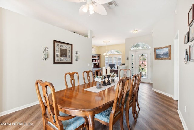 dining space with ceiling fan with notable chandelier and dark wood-type flooring