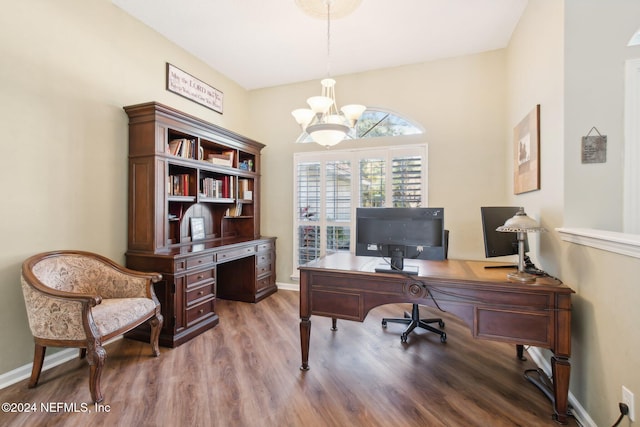 home office with wood-type flooring and a chandelier