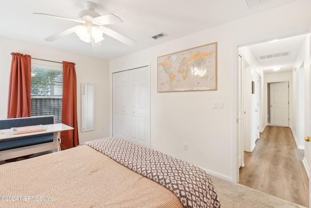 bedroom with light hardwood / wood-style floors, a closet, and ceiling fan