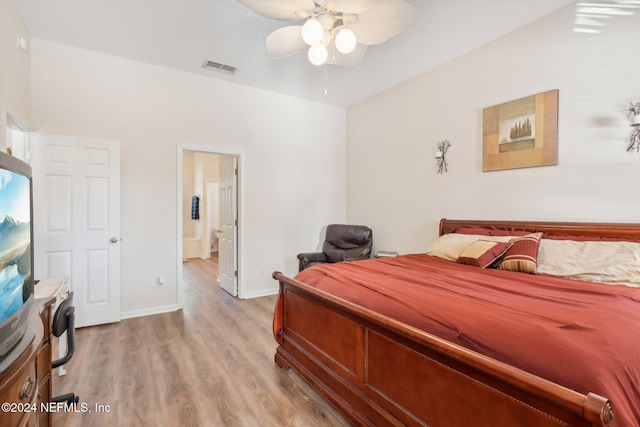 bedroom featuring ceiling fan, light wood-type flooring, and ensuite bath