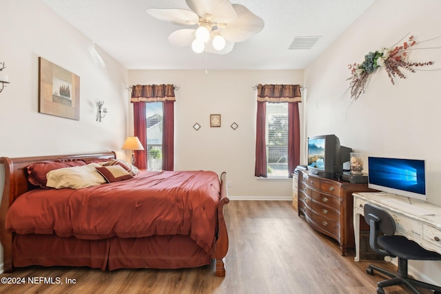 bedroom with multiple windows, ceiling fan, and light hardwood / wood-style flooring