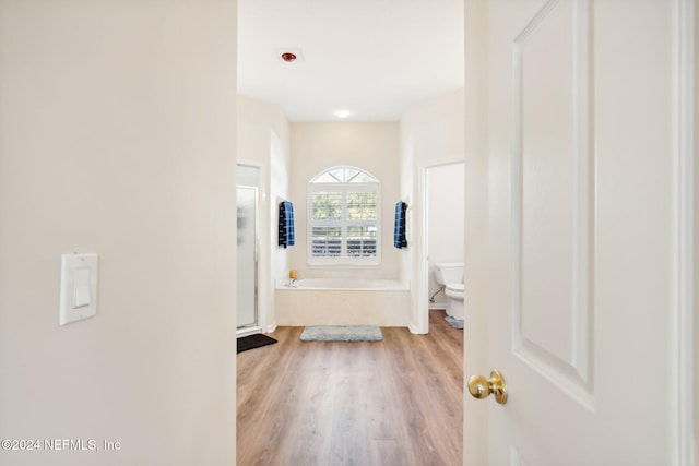 bathroom with wood-type flooring, toilet, and a bathing tub