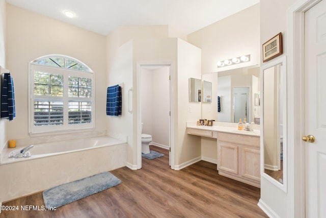 bathroom featuring hardwood / wood-style floors, a bathtub, toilet, and vanity