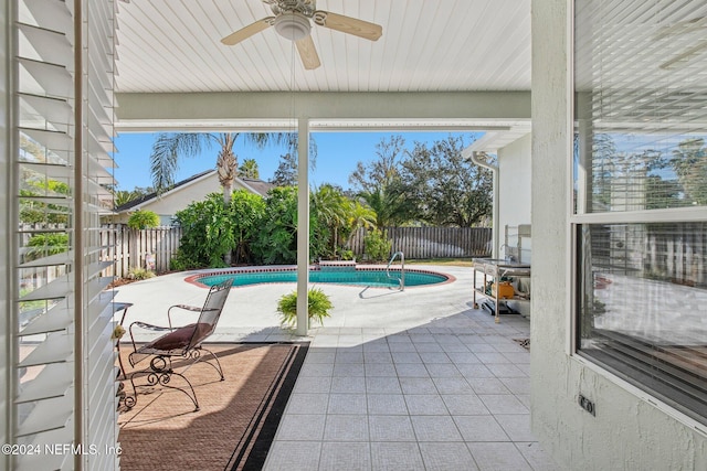 view of swimming pool featuring ceiling fan and a patio area