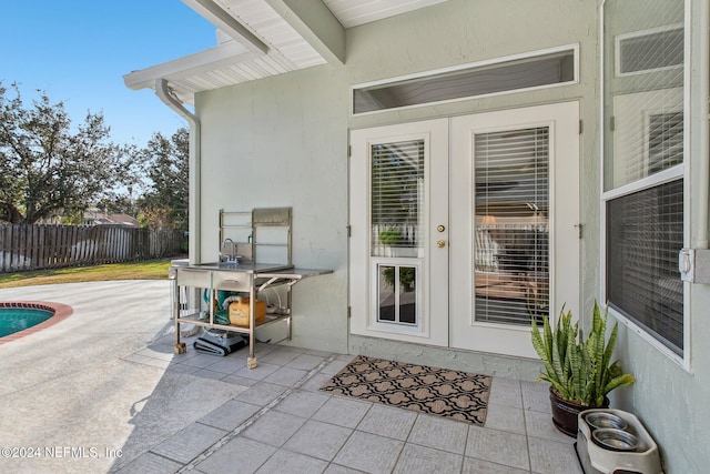 view of exterior entry featuring a patio area and french doors