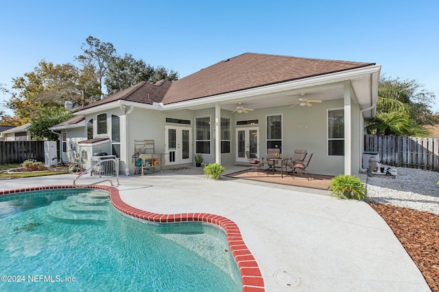 rear view of property featuring ceiling fan, a patio area, a fenced in pool, and french doors