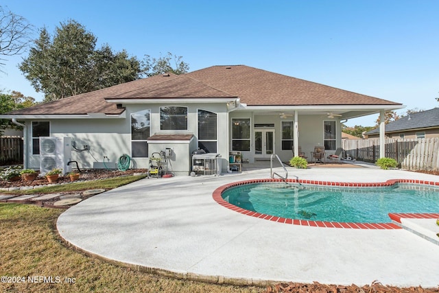 rear view of house with ceiling fan, a patio area, a fenced in pool, and french doors