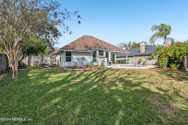 rear view of property featuring a patio area and a yard