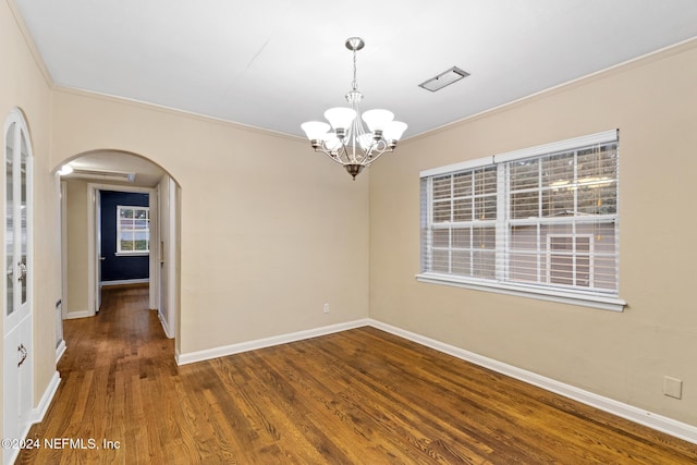 unfurnished room with crown molding, dark wood-type flooring, and a notable chandelier