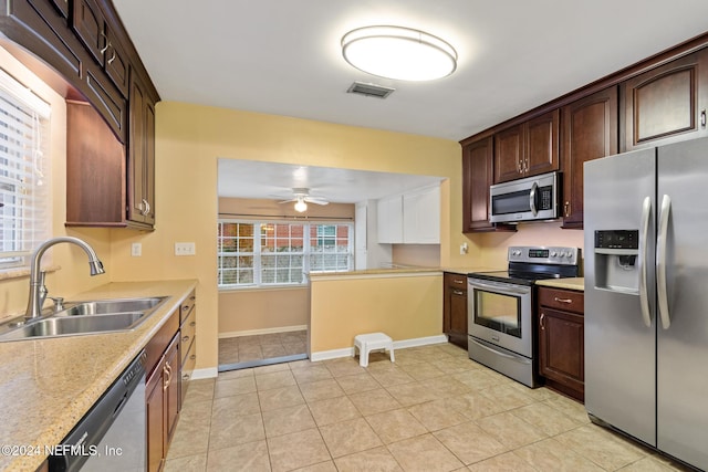 kitchen featuring sink, ceiling fan, light tile patterned floors, appliances with stainless steel finishes, and dark brown cabinetry