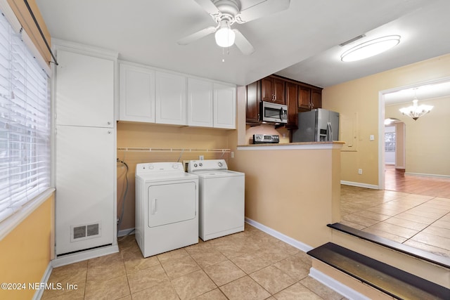 laundry room featuring ceiling fan with notable chandelier, light tile patterned flooring, and separate washer and dryer