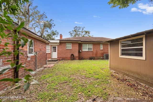 back of property featuring a lawn and central AC unit