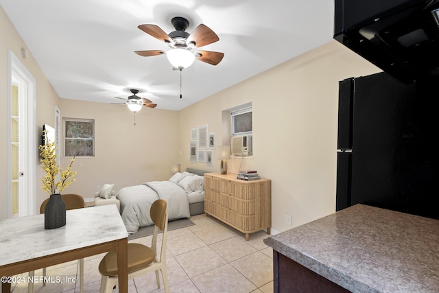 tiled bedroom with black fridge and ceiling fan