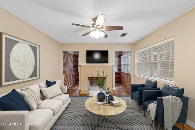 living room with ceiling fan, wood-type flooring, and ornamental molding