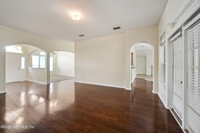 empty room with dark hardwood / wood-style flooring