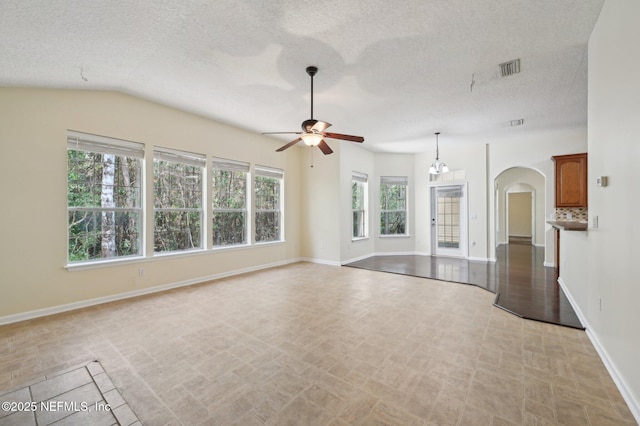 unfurnished living room featuring a textured ceiling, vaulted ceiling, and ceiling fan