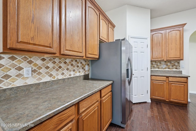 kitchen featuring stainless steel fridge with ice dispenser, tasteful backsplash, and dark wood-type flooring