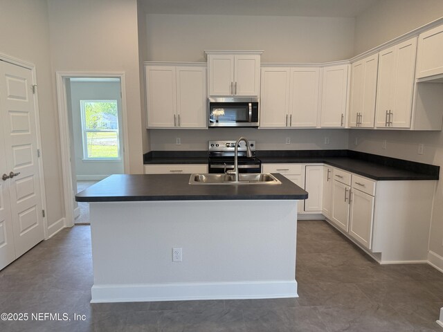 8195 Elsdon St, Jacksonville, FL 32219 - kitchen with a sink, dark countertops, appliances with stainless steel finishes, and white cabinetry