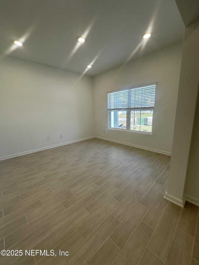 empty room with recessed lighting, baseboards, and wood finish floors