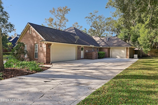 view of front of home featuring a garage, central air condition unit, and a front lawn