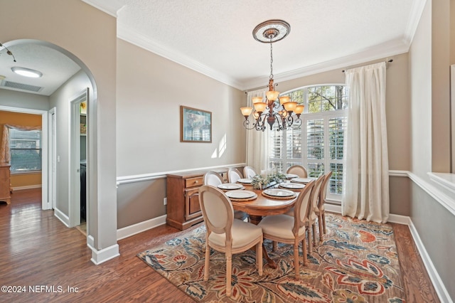 dining area with a notable chandelier, dark hardwood / wood-style floors, and ornamental molding