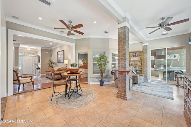 tiled living room with ornate columns, ceiling fan, and crown molding