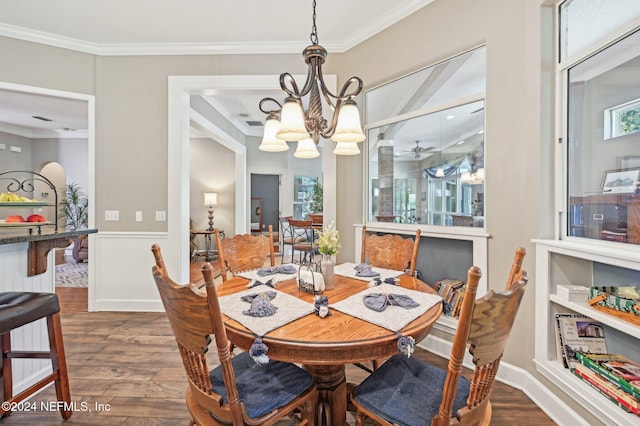 dining room featuring crown molding, dark wood-type flooring, and ceiling fan with notable chandelier