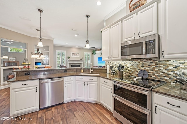 kitchen featuring kitchen peninsula, white cabinets, and appliances with stainless steel finishes