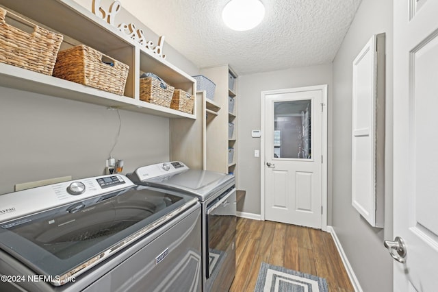 laundry room with a textured ceiling, independent washer and dryer, and dark wood-type flooring