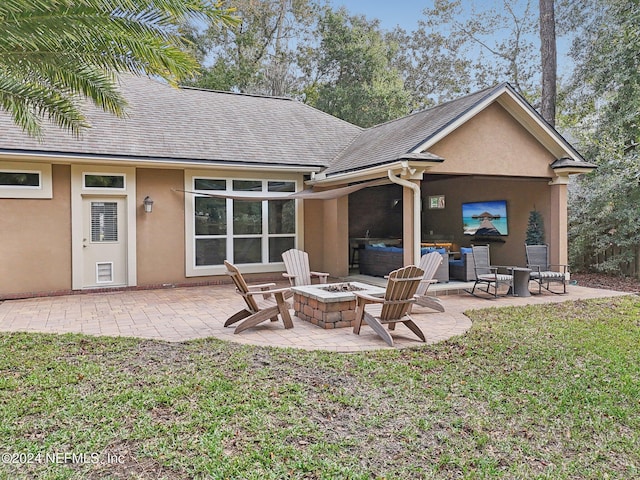 rear view of house with a lawn, an outdoor fire pit, and a patio