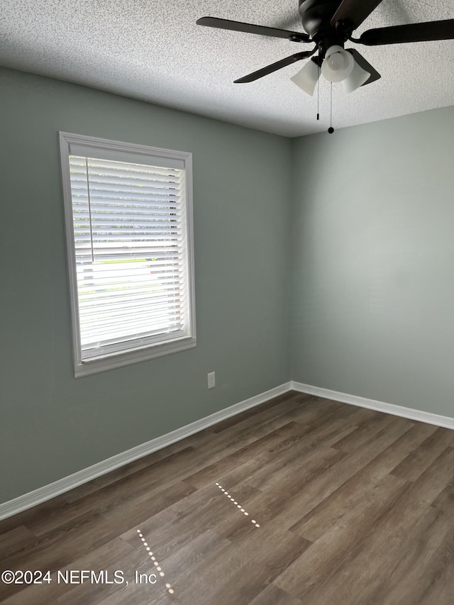 spare room featuring ceiling fan, dark hardwood / wood-style flooring, and a textured ceiling