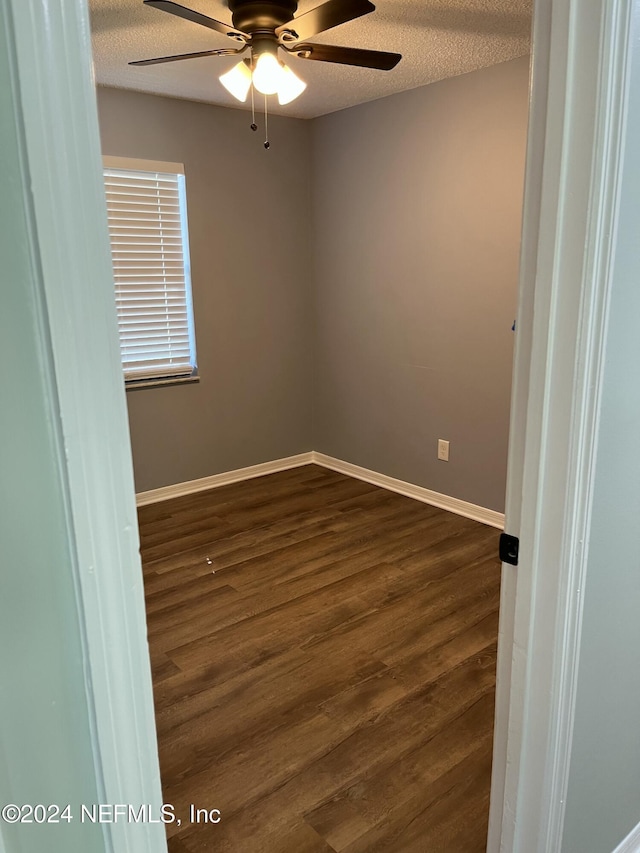 unfurnished room featuring a textured ceiling, dark hardwood / wood-style floors, and ceiling fan