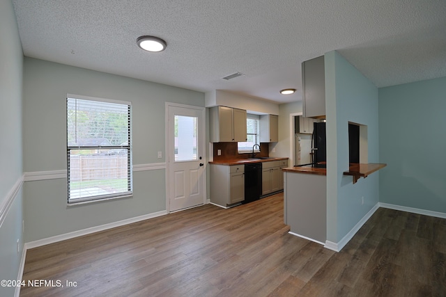 kitchen with black appliances, butcher block counters, dark wood-type flooring, and a textured ceiling