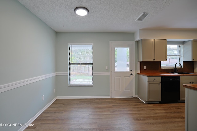 kitchen featuring wood counters, sink, hardwood / wood-style floors, and black dishwasher