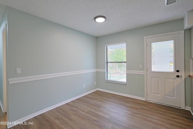 entrance foyer with light hardwood / wood-style floors and a textured ceiling