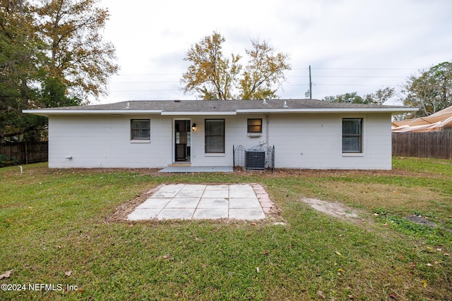 back of house with a yard and central air condition unit