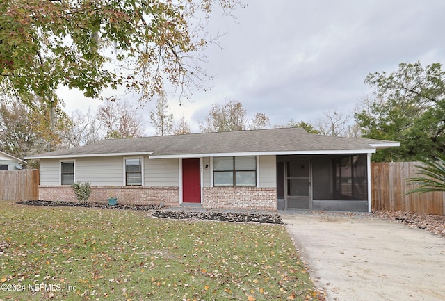 single story home featuring a sunroom and a front yard