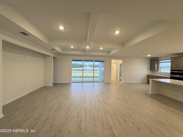 unfurnished living room featuring light wood finished floors, visible vents, recessed lighting, and baseboards