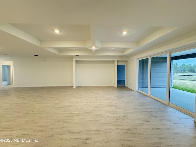 empty room with light wood finished floors, recessed lighting, coffered ceiling, and baseboards