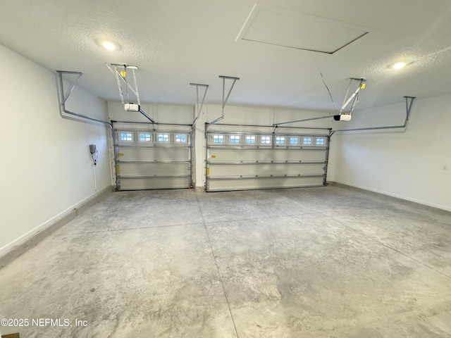 garage featuring a garage door opener and baseboards