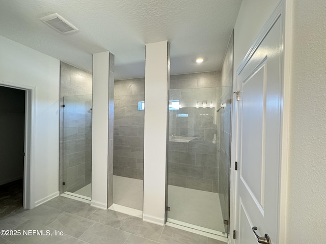 full bathroom featuring a shower stall, visible vents, tile patterned floors, and a textured ceiling